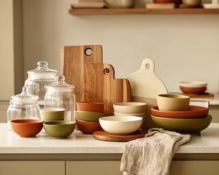 Accesorios decorativos para cocina con frascos, tablas de madera y textiles en tonos tierra
